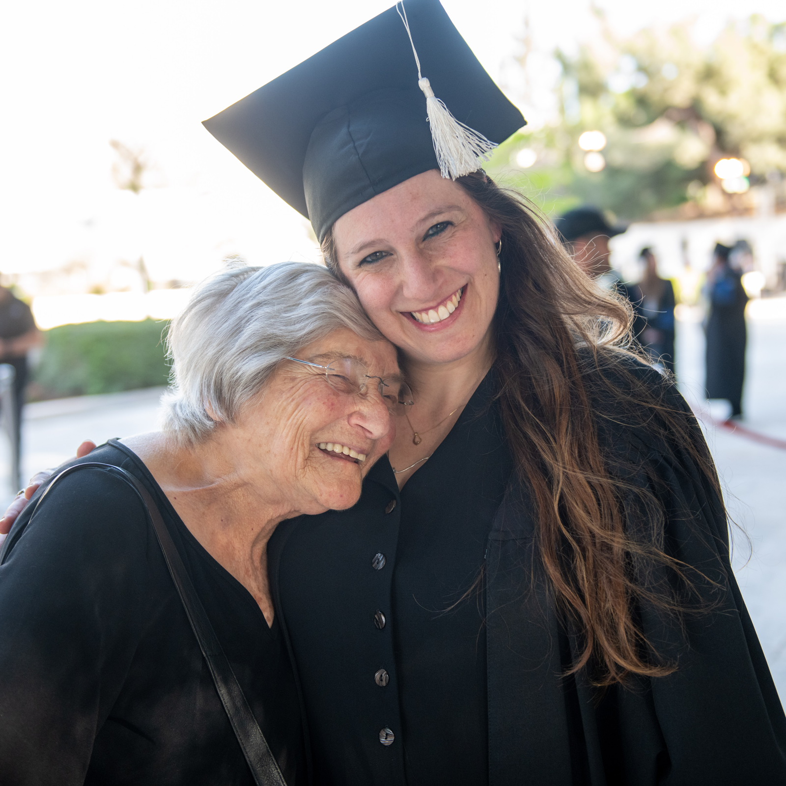 Graduate smiling with family member at graduation